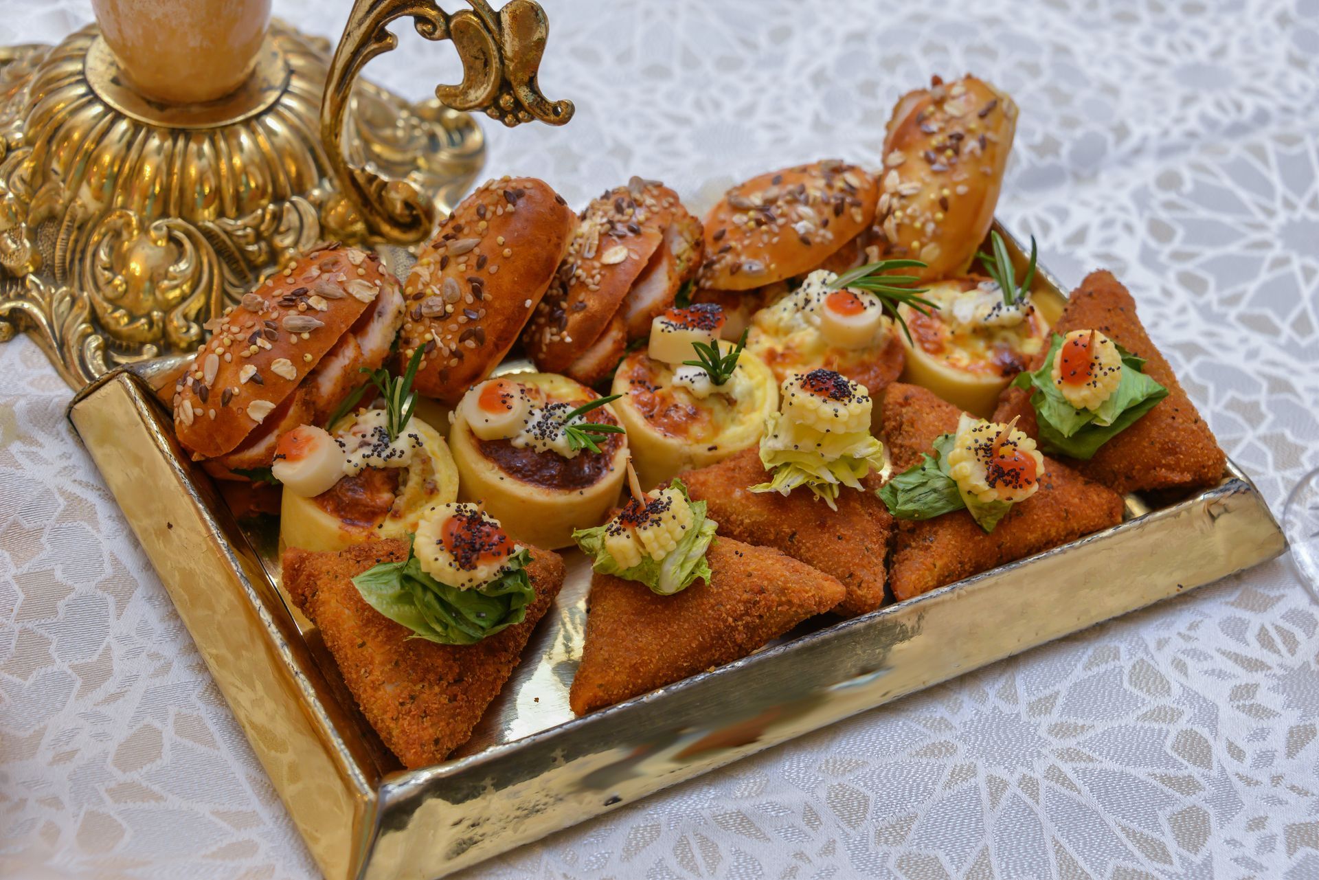 Plateau de hors-d'œuvre salés assortis avec pain grillé, avocat et garniture, présenté sur une nappe décorative.