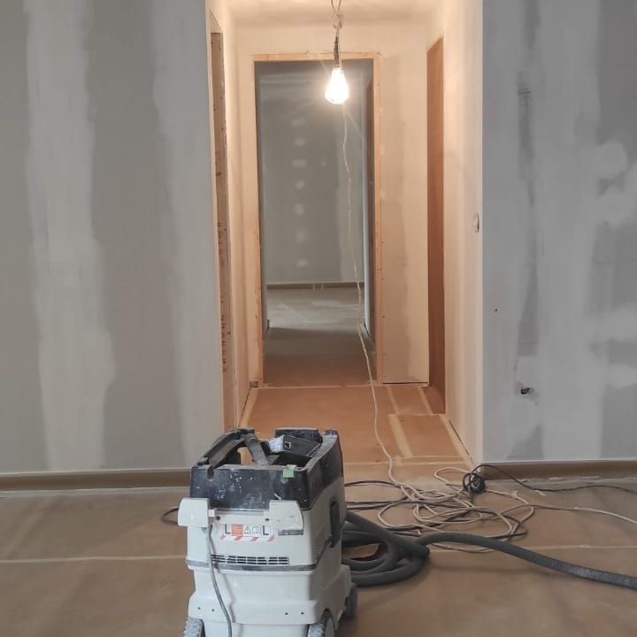 Una aspiradora está en el suelo de un pasillo.