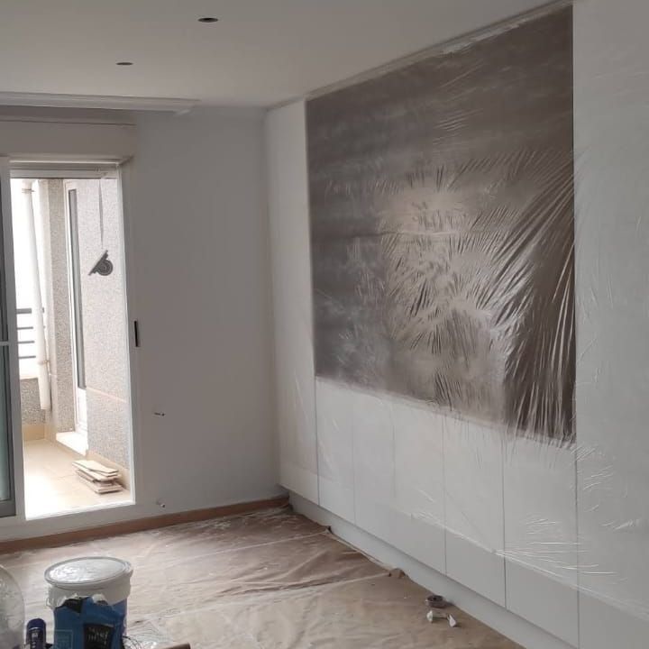 Se está pintando una habitación con un cuadro grande en la pared.
