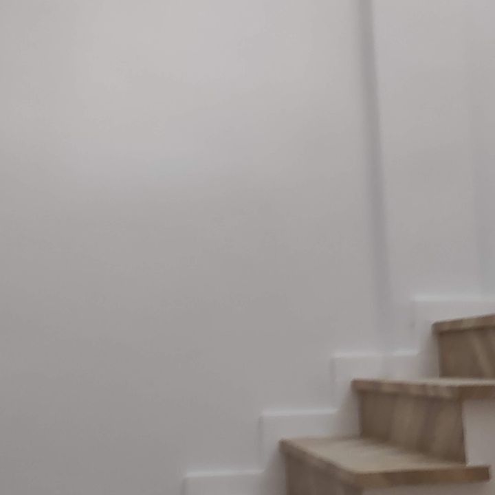 Un primer plano de un conjunto de escaleras con una pared blanca al fondo.