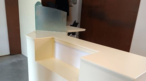 Un mostrador blanco con un divisor de vidrio en una habitación.