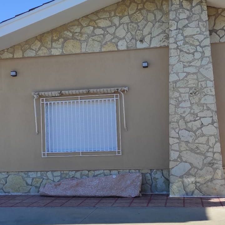 Un edificio de piedra con una ventana con una valla alrededor.