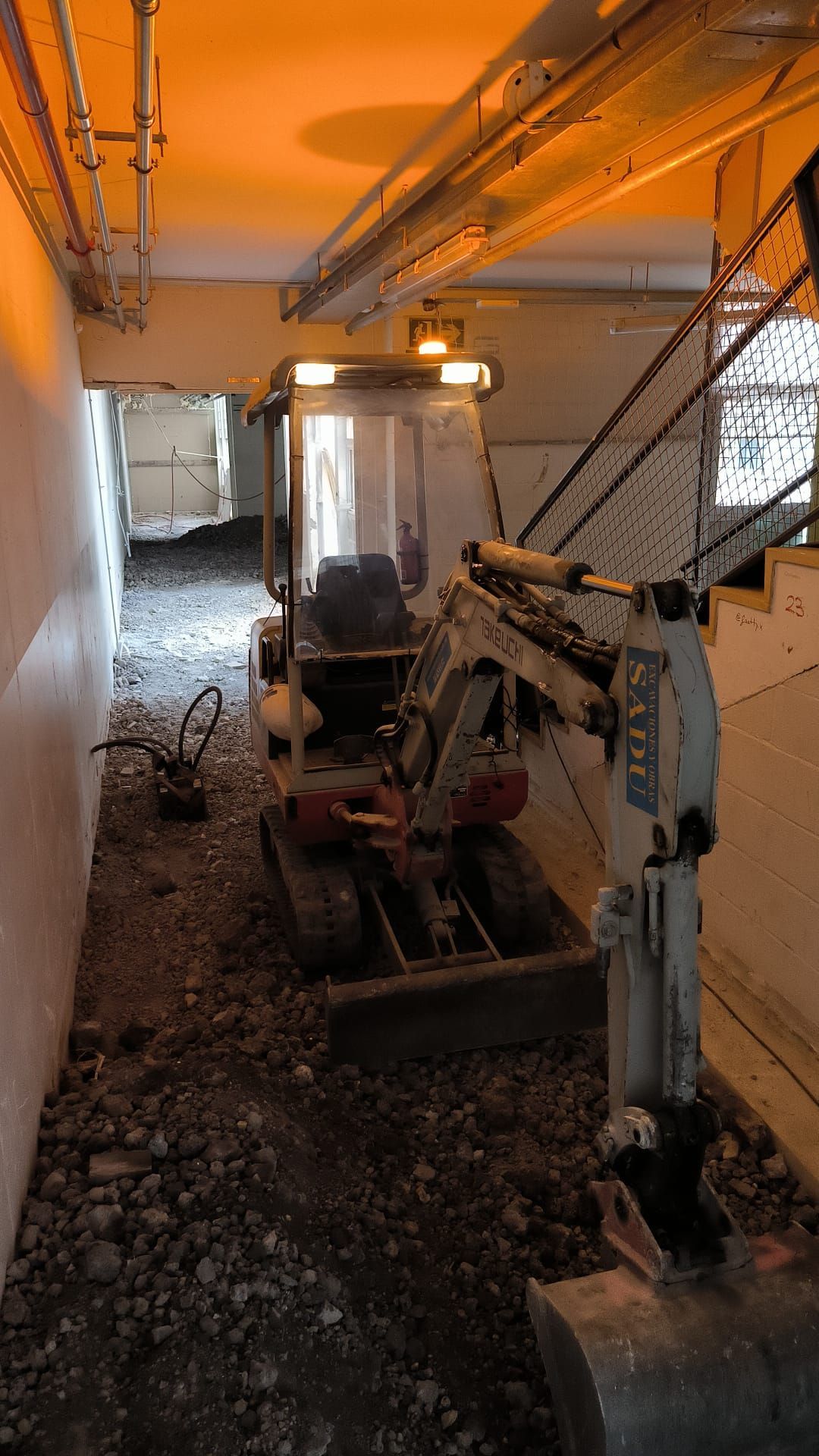 Una pequeña excavadora está en el medio de un túnel.