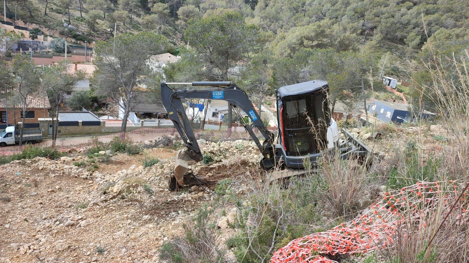 Una pequeña excavadora está cavando un hoyo en el suelo.