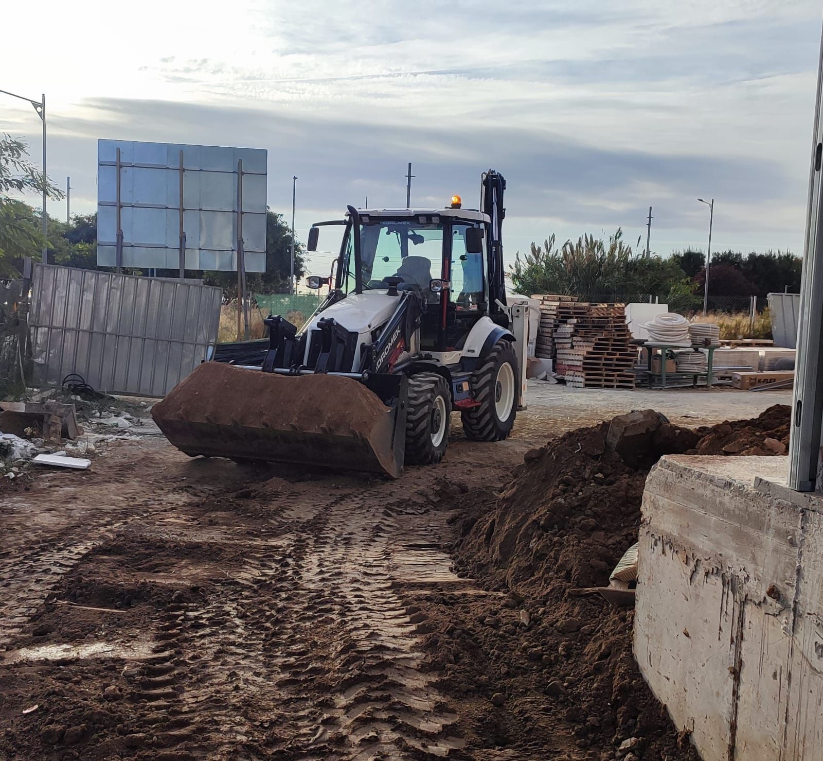 Una excavadora está moviendo tierra en un sitio de construcción