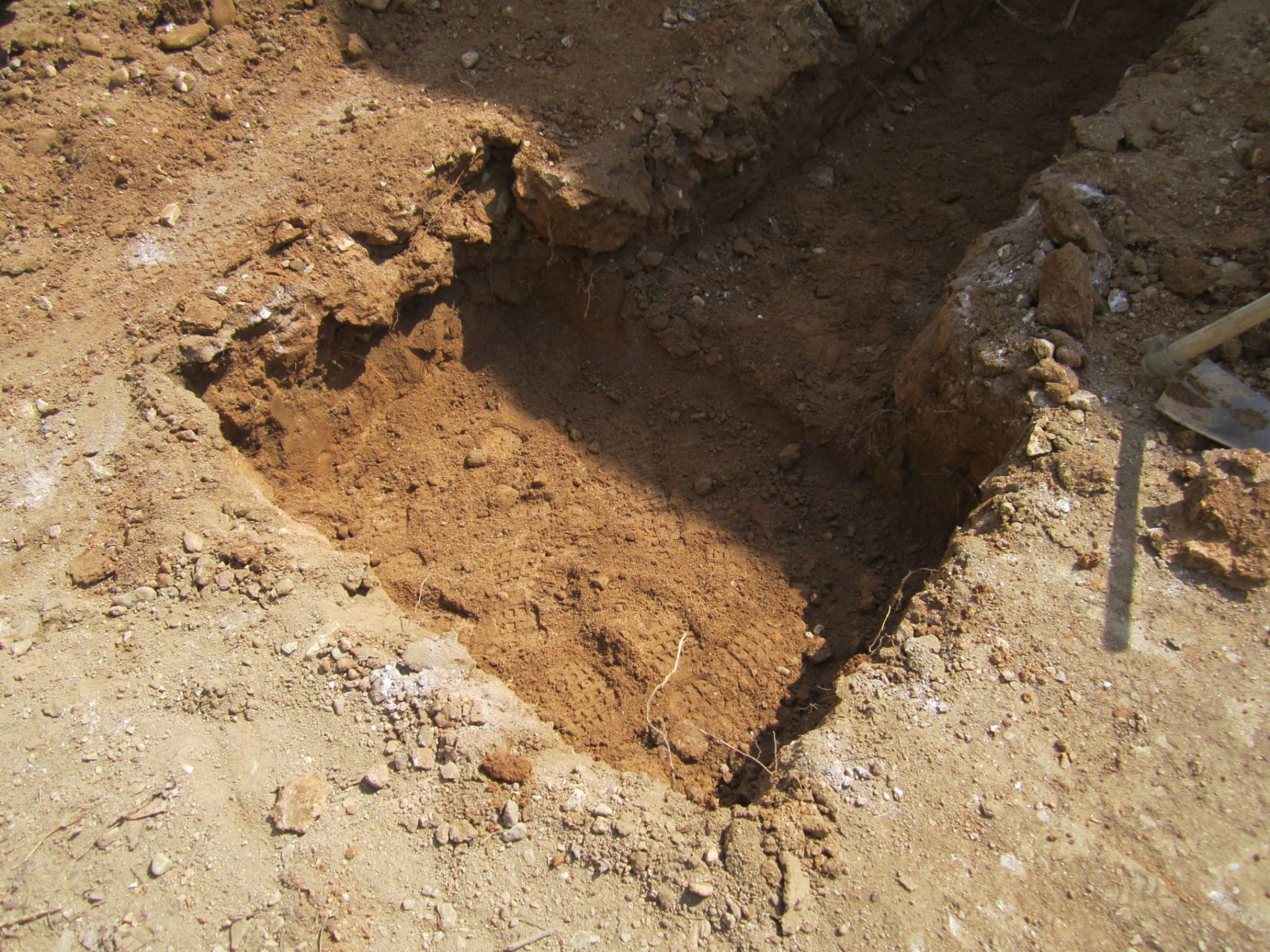 Un agujero en el suelo con una pala dentro