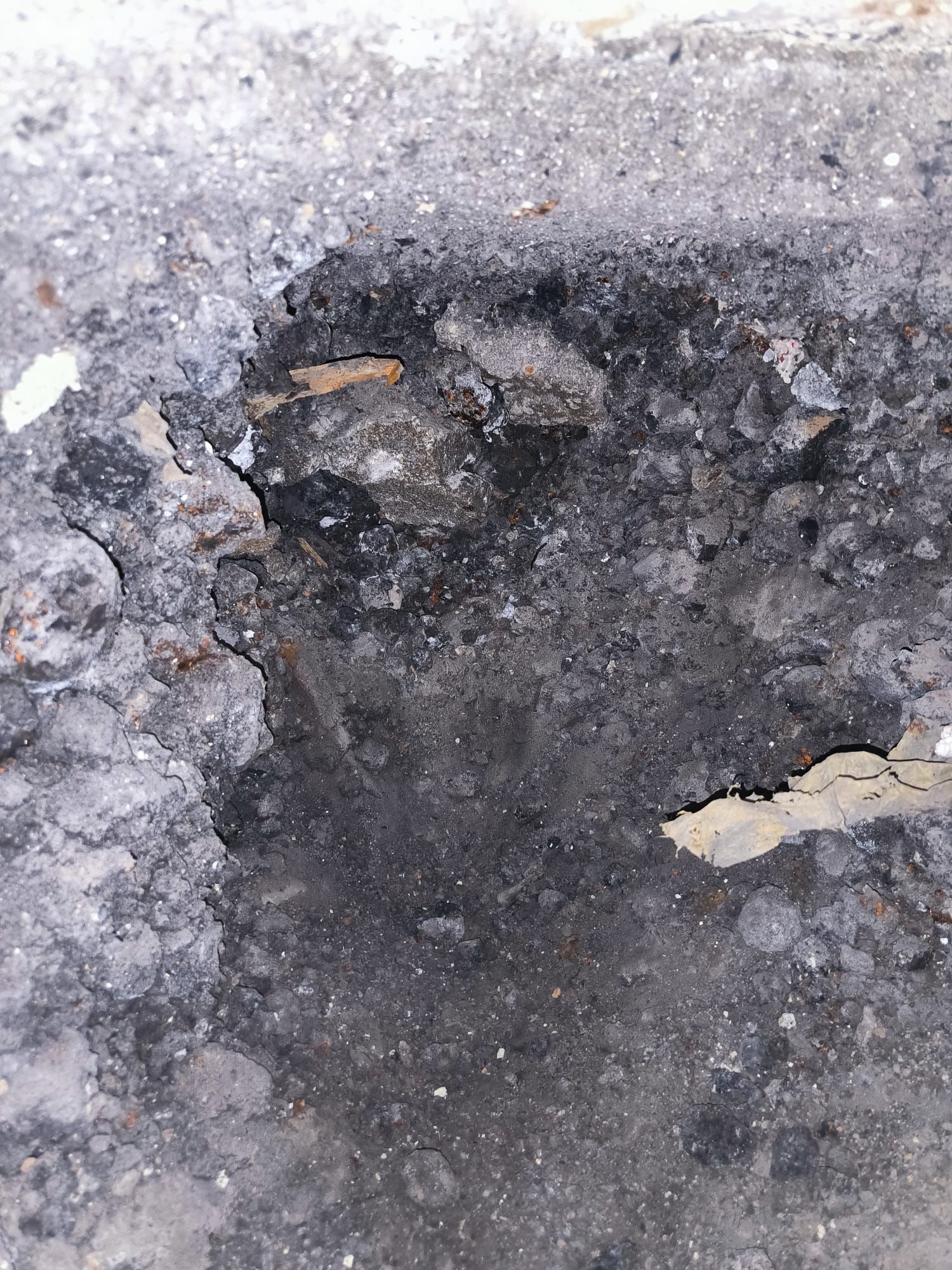 Un primer plano de una superficie de hormigón con un agujero en ella.