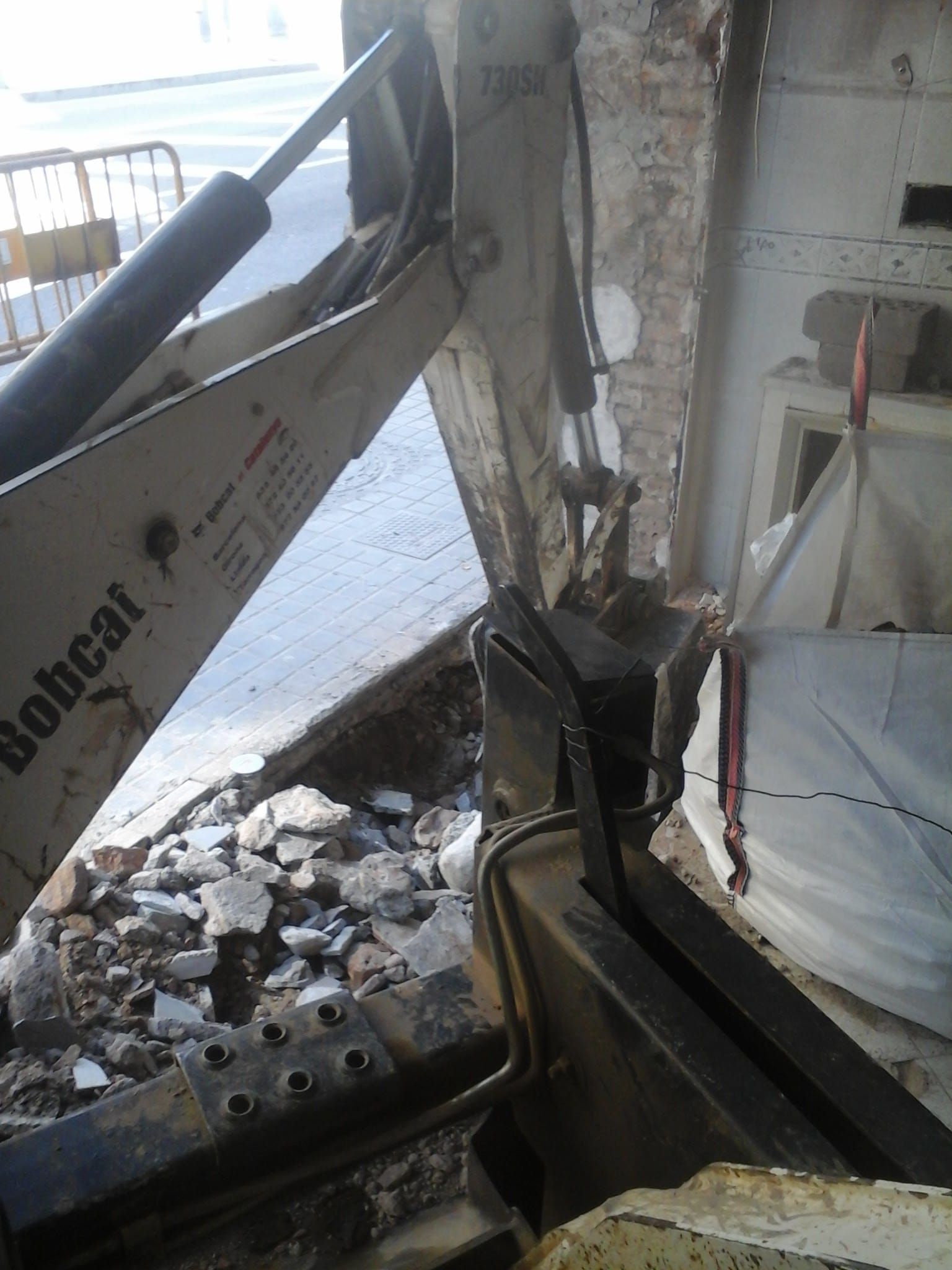 Una excavadora Bobcat está sentada en una pila de rocas