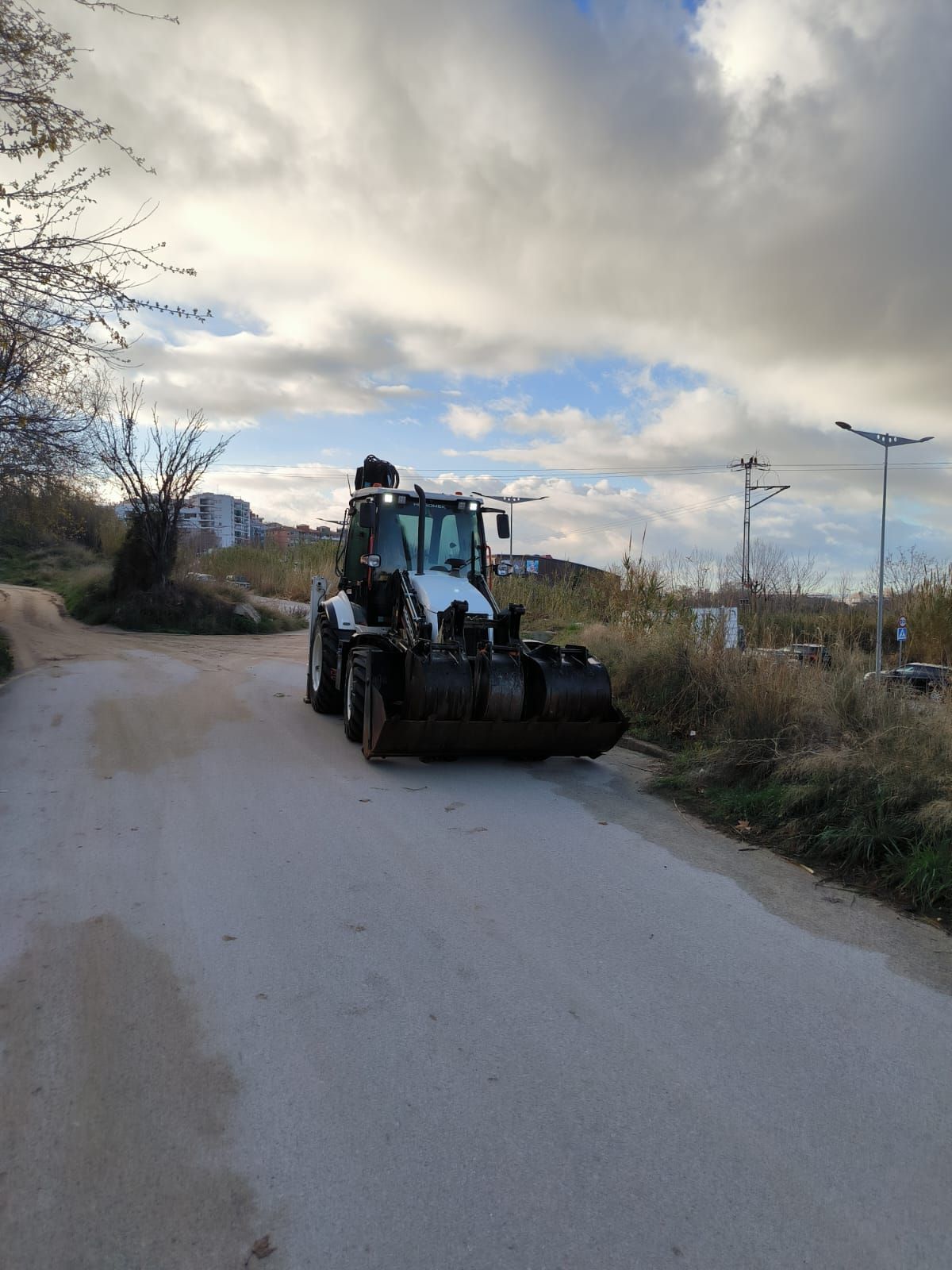 Una excavadora avanza por un camino de tierra.