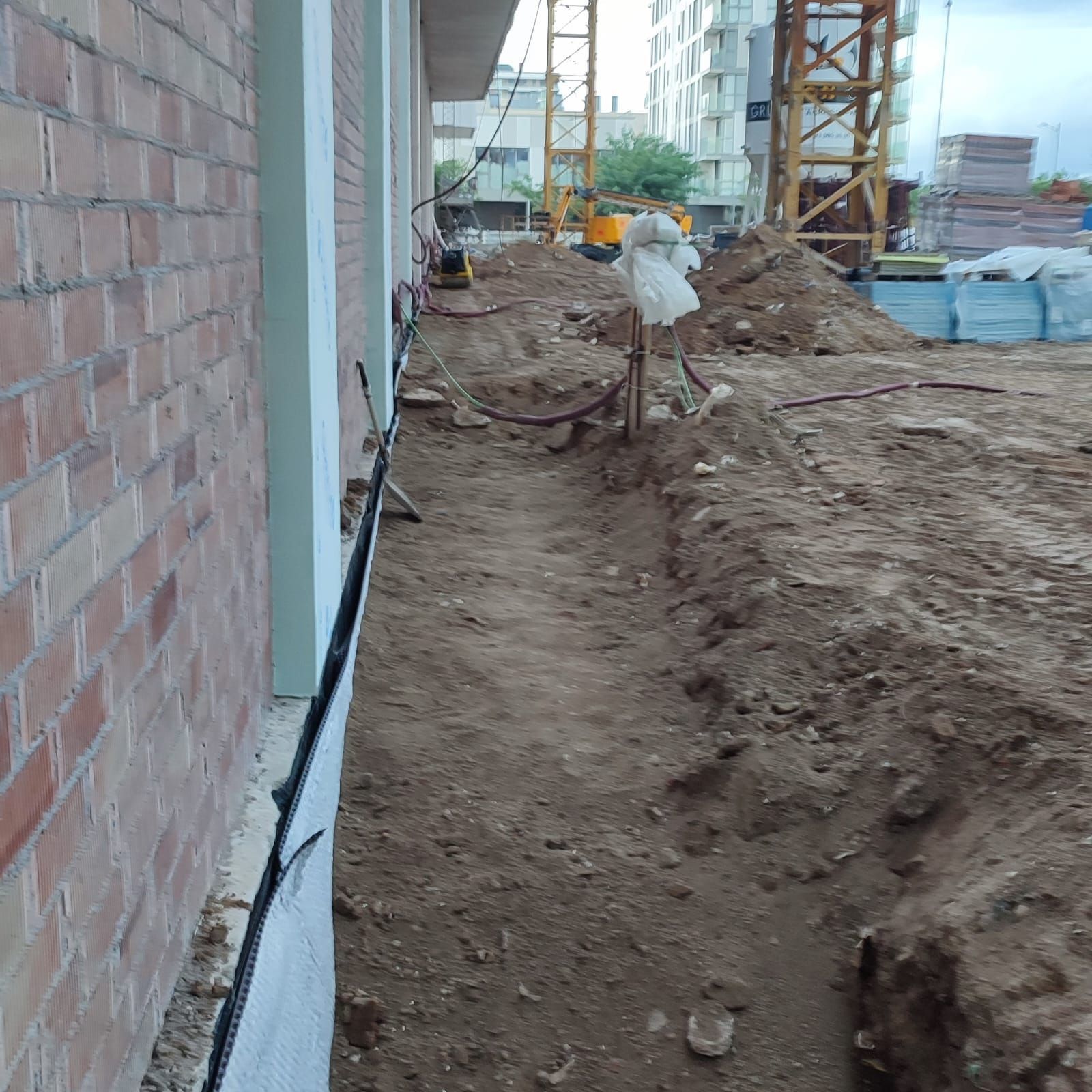 Un sitio de construcción con una grúa al fondo