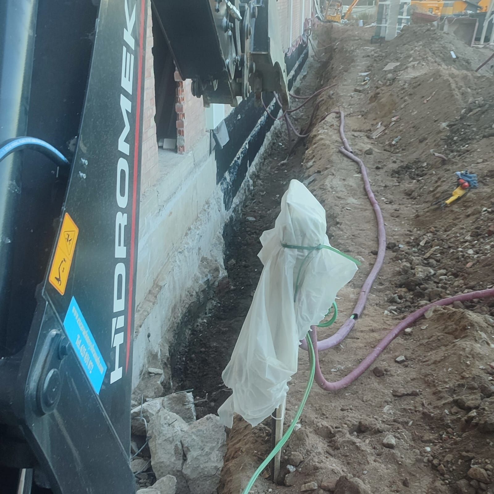 Se está utilizando una máquina Hydromek para cavar un hoyo en el suelo.