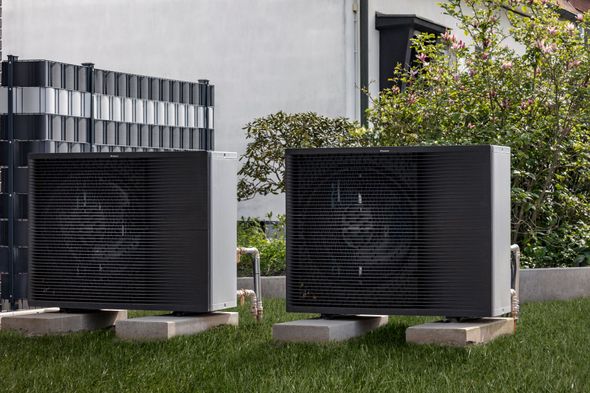 Deux unités de climatisation extérieures noires, installées sur des dalles de béton