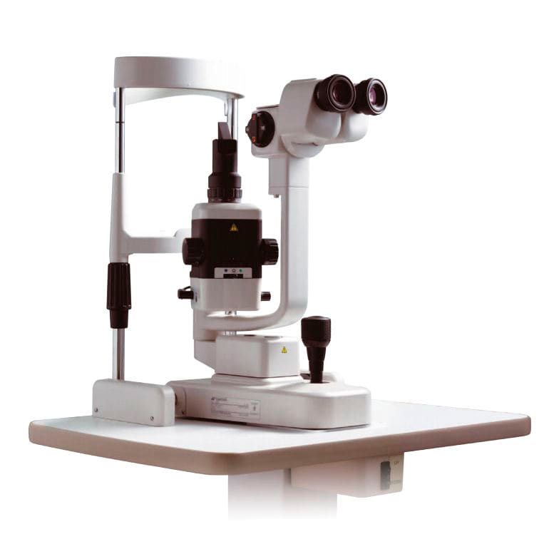 Un microscopio blanco está sobre una mesa blanca.