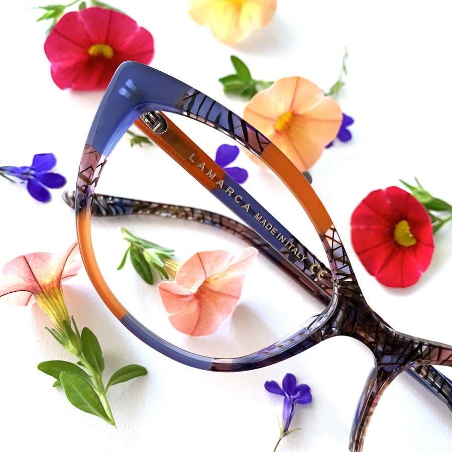 Un par de gafas Lamarca rodeadas de flores.