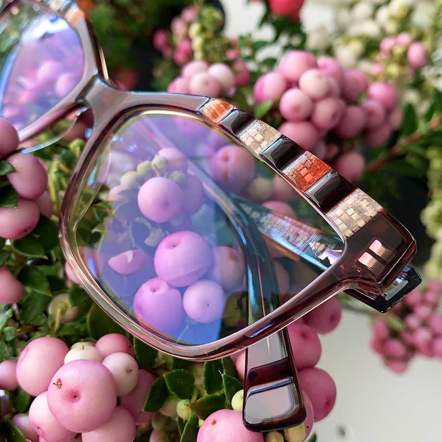 Un par de gafas sobre un ramo de flores rosas.