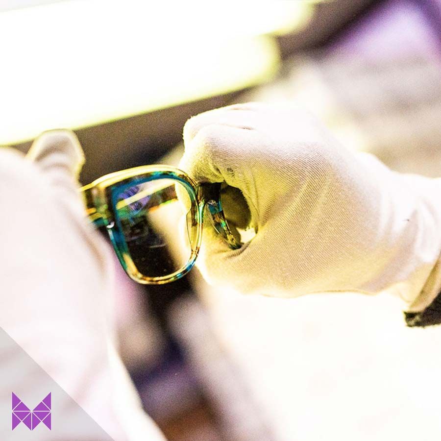 Una persona que lleva guantes blancos sostiene un par de gafas.