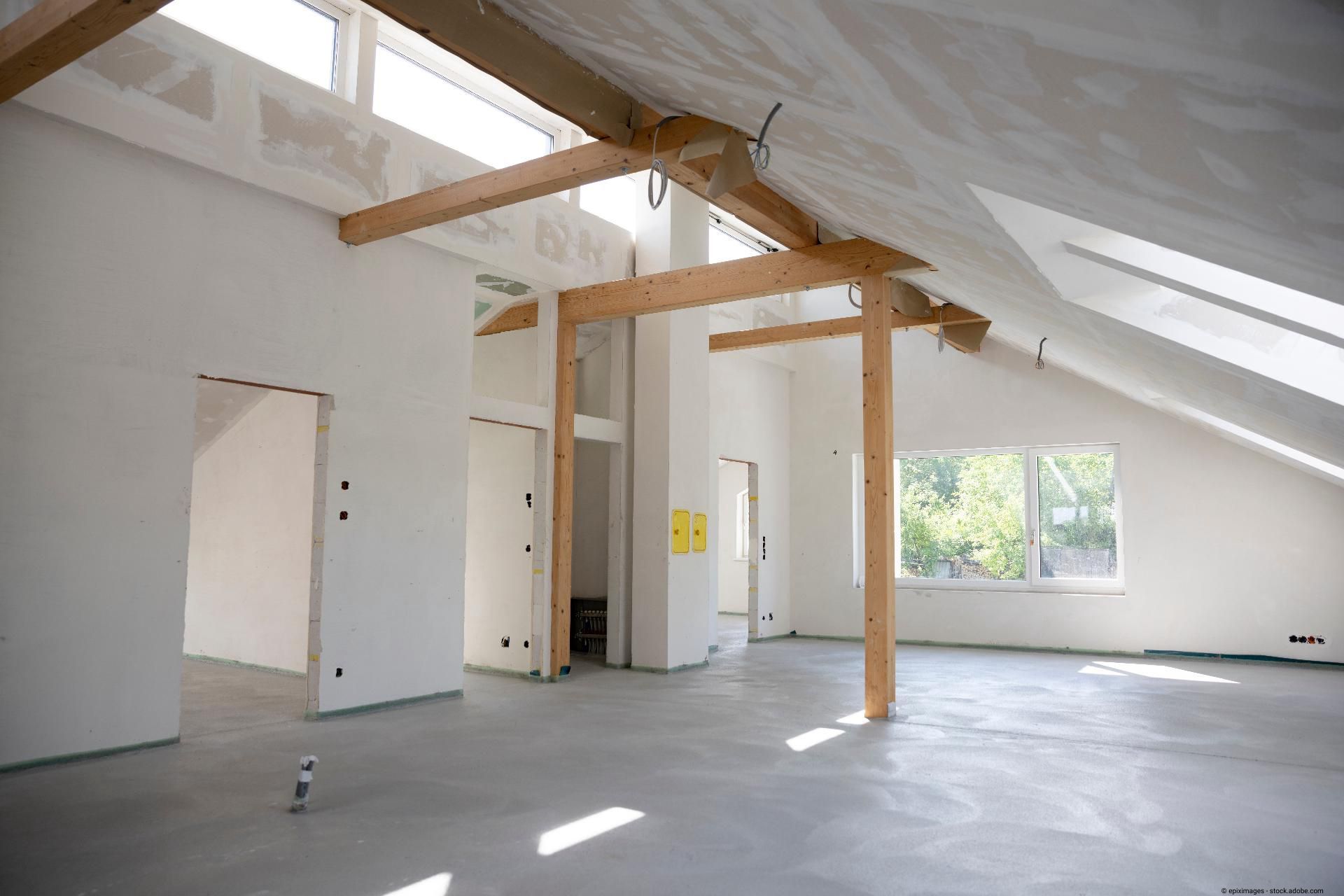 Renovierter Innenraum mit hellem Estrichboden und sichtbaren Holzbalken.