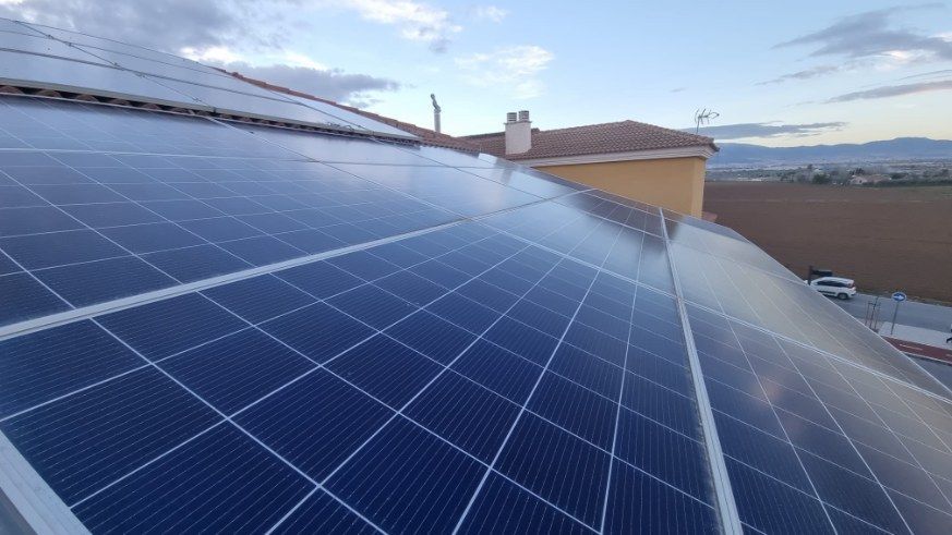 Dos trabajadores instalando paneles solares en un tejado.