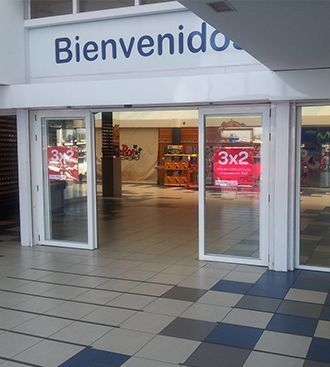Entrada a una tienda con puertas corredizas de vidrio y un letrero de 