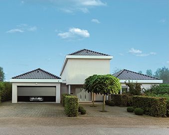 Casa moderna con una puerta de garaje gris entreabierta, dejando ver un coche en el interior. Paredes exteriores claras, tejas oscuras y arbustos bien podados.