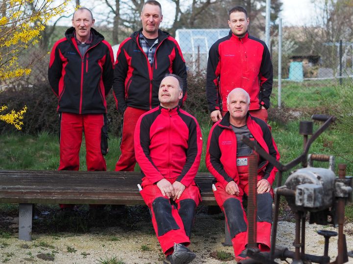 Holztisch mit schwarzen Metallbeinen in einem Raum mit Treppe.