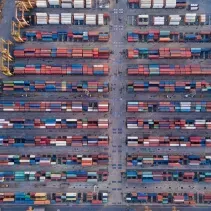 Overhead view of a shipping port filled with rows of colorful cargo containers.