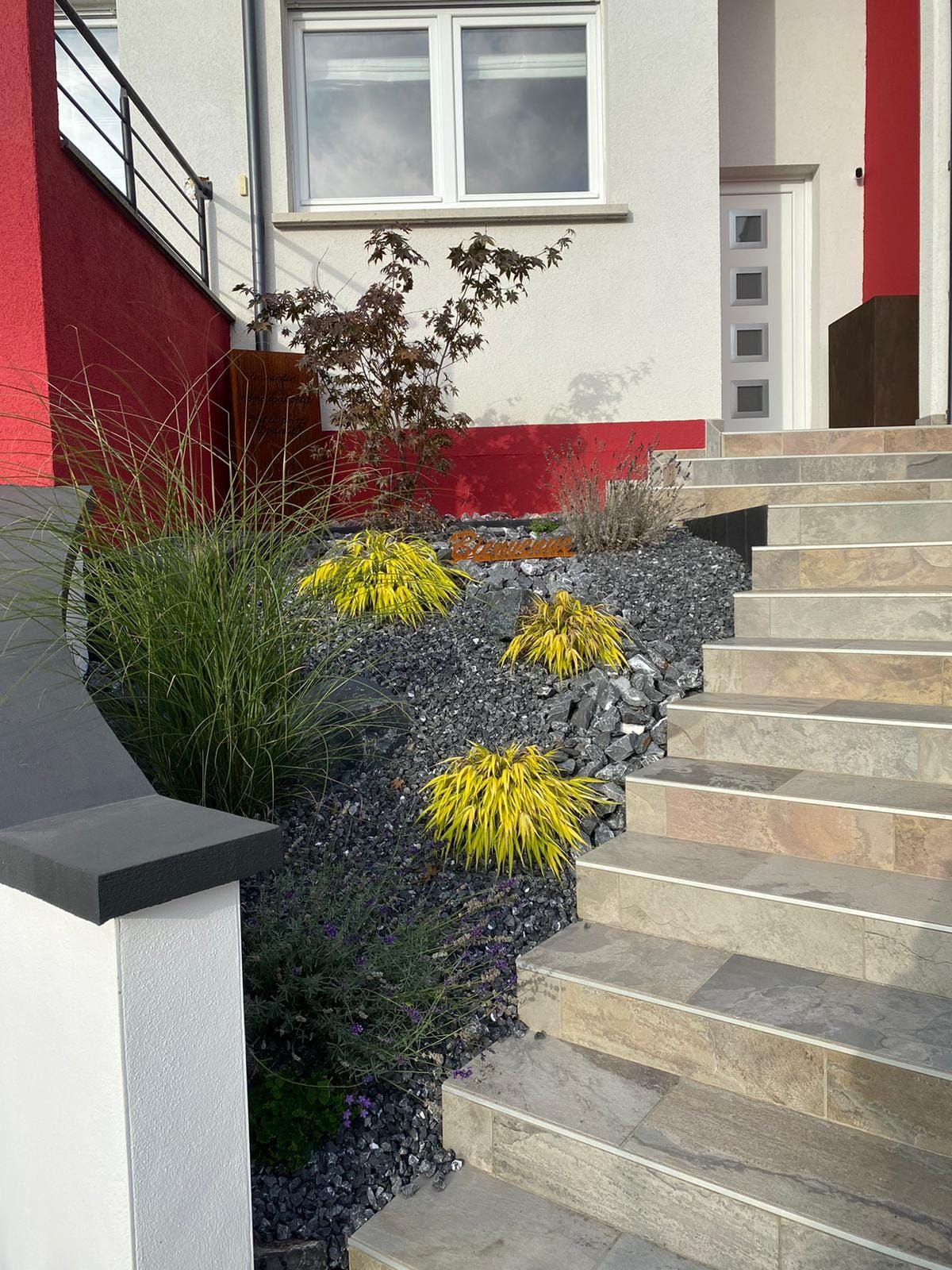 Marches d'escalier avec un massif en pierres noires à côté