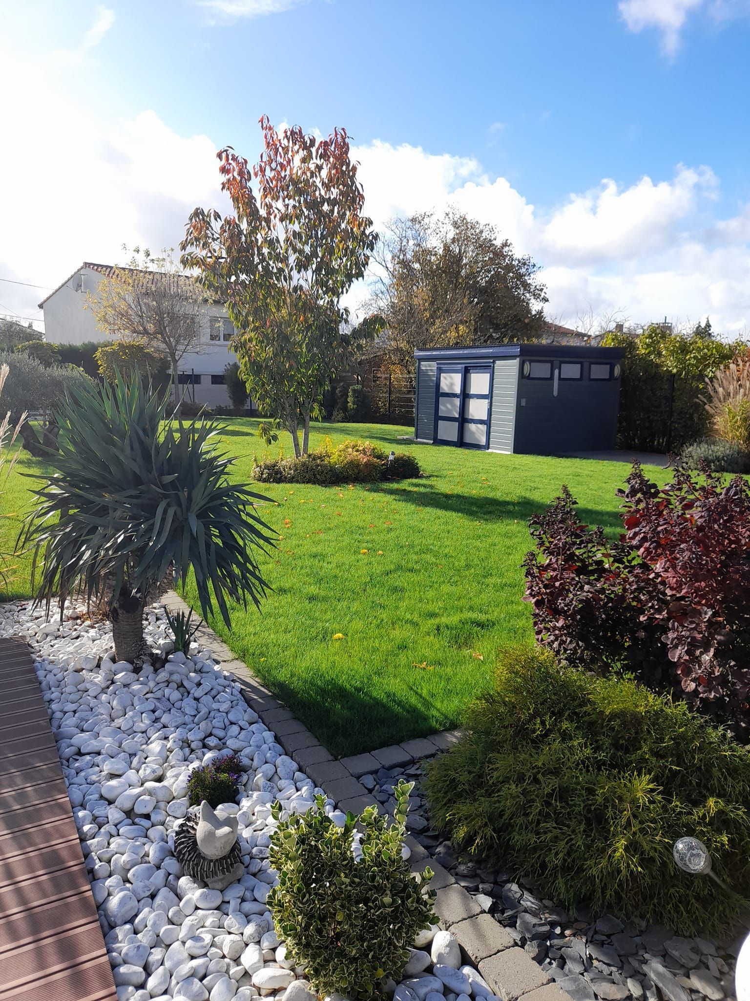 Jardin élégant avec des îlots de galets et des plantes diverses