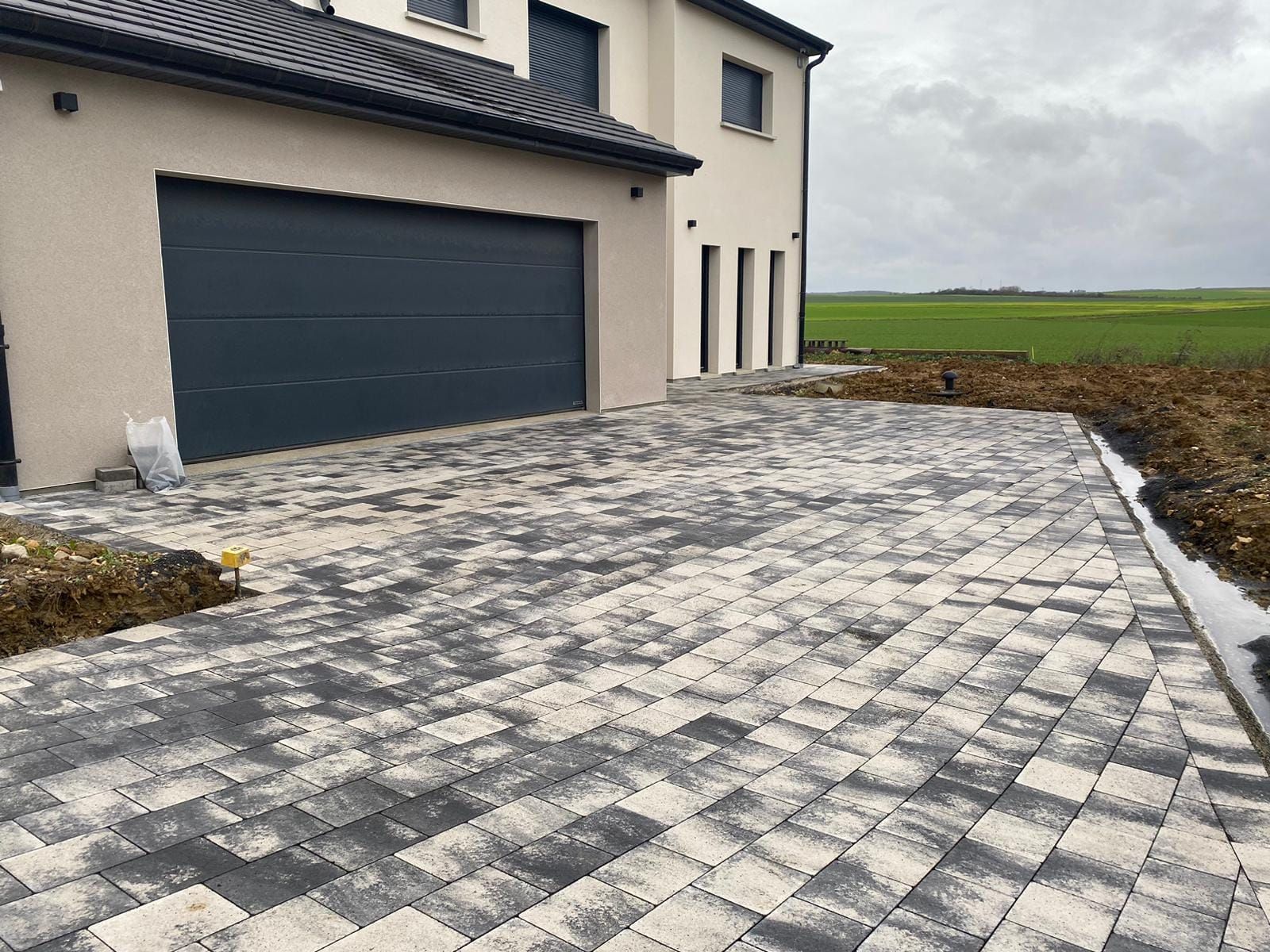 Allée de jardin pavée devant un garage