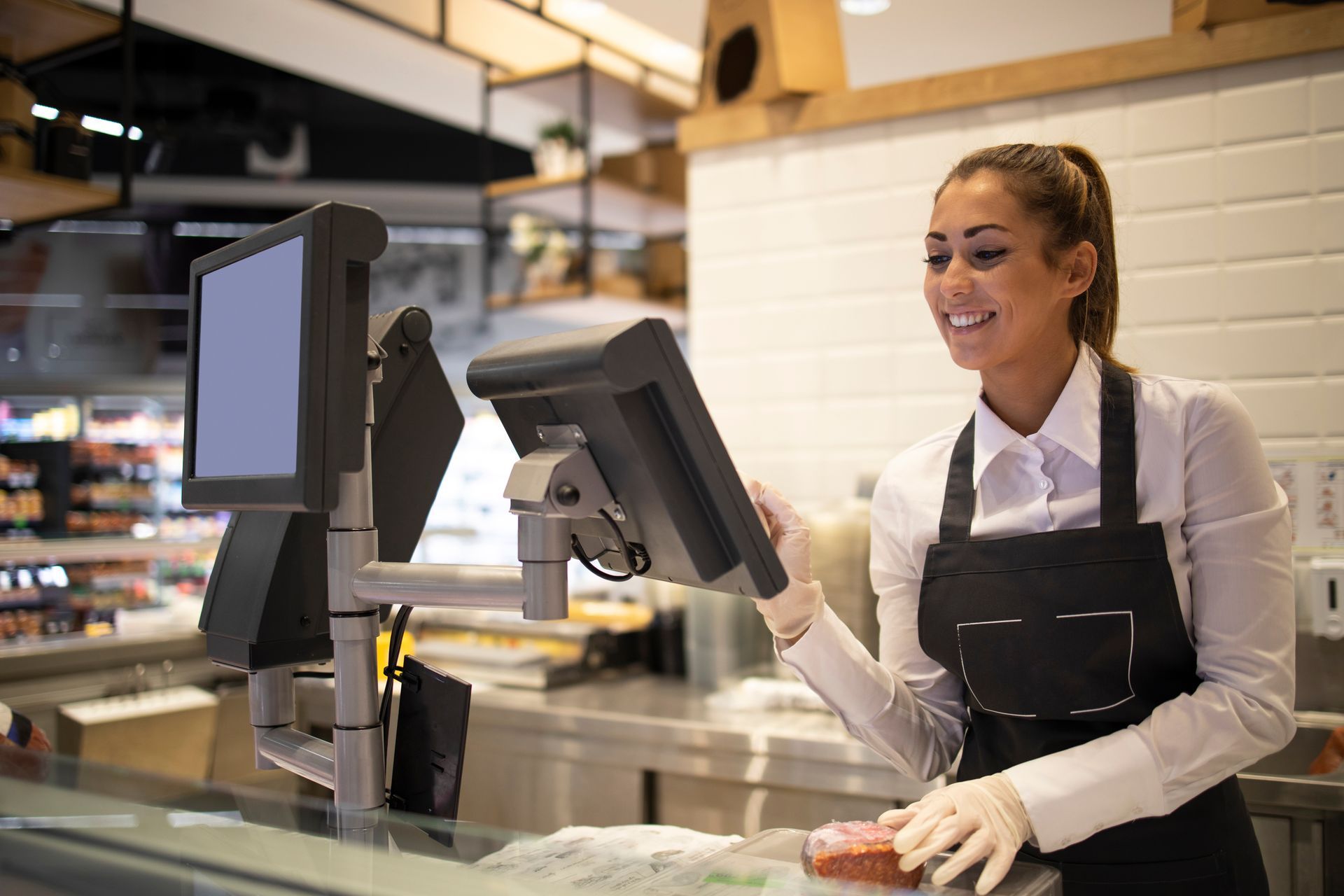 Femme tapant sur une machine tactile pour la pesée d'un bout de viande