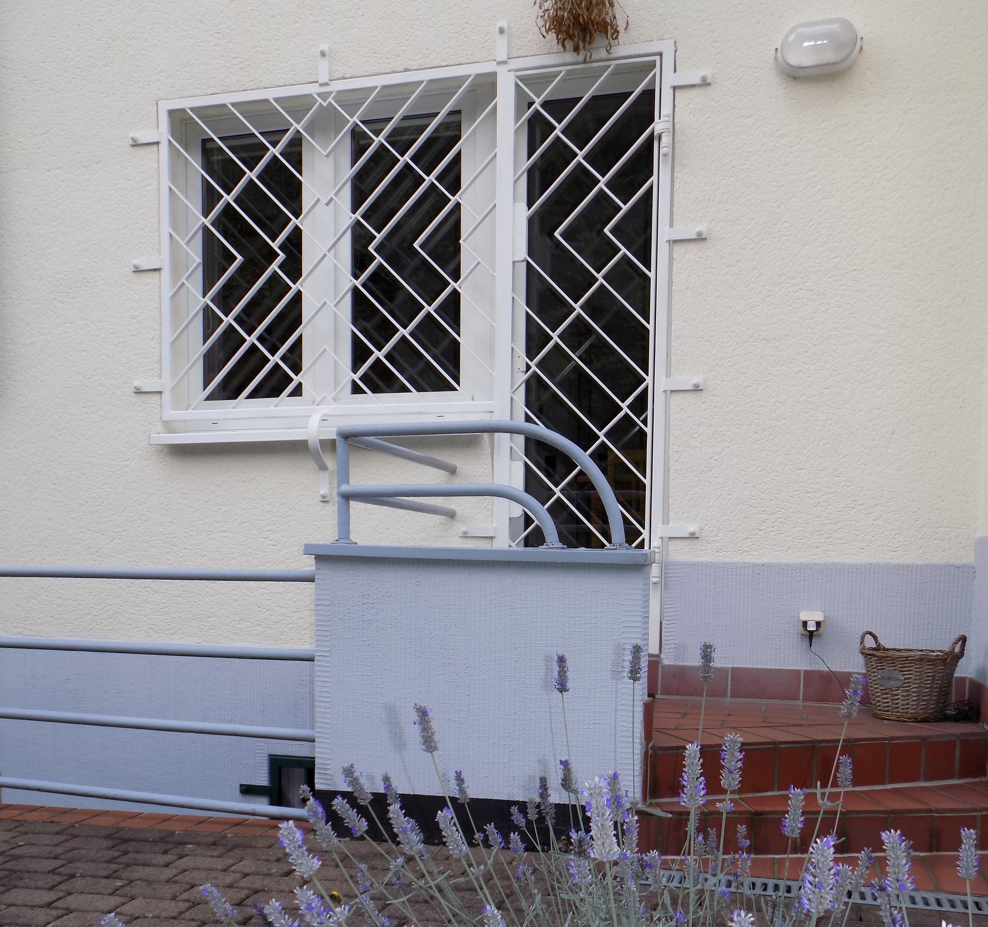 Ein weißes Haus mit lila Blumen davor