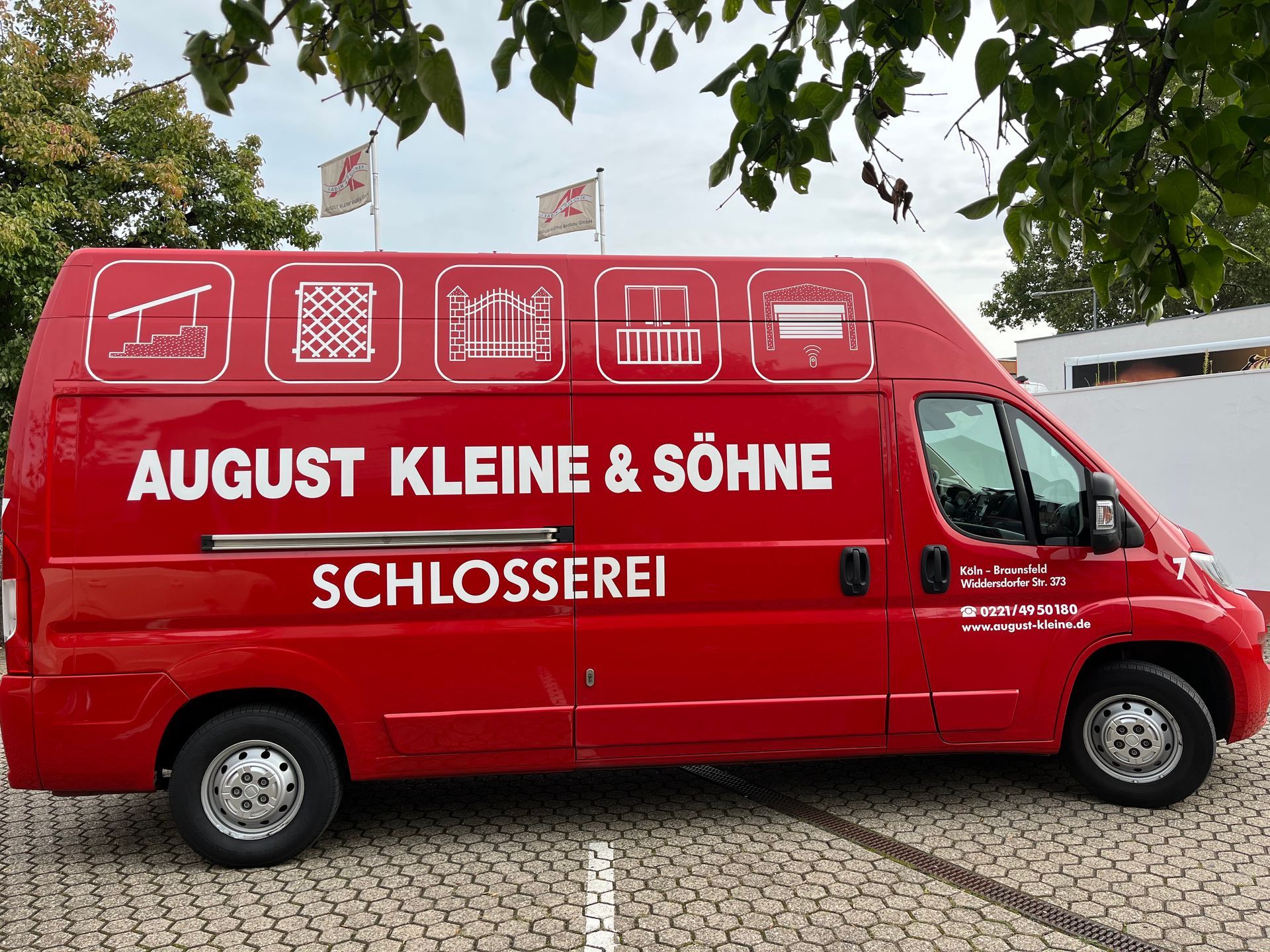 Ein roter August Kleine & Söhne Van steht auf einem Parkplatz