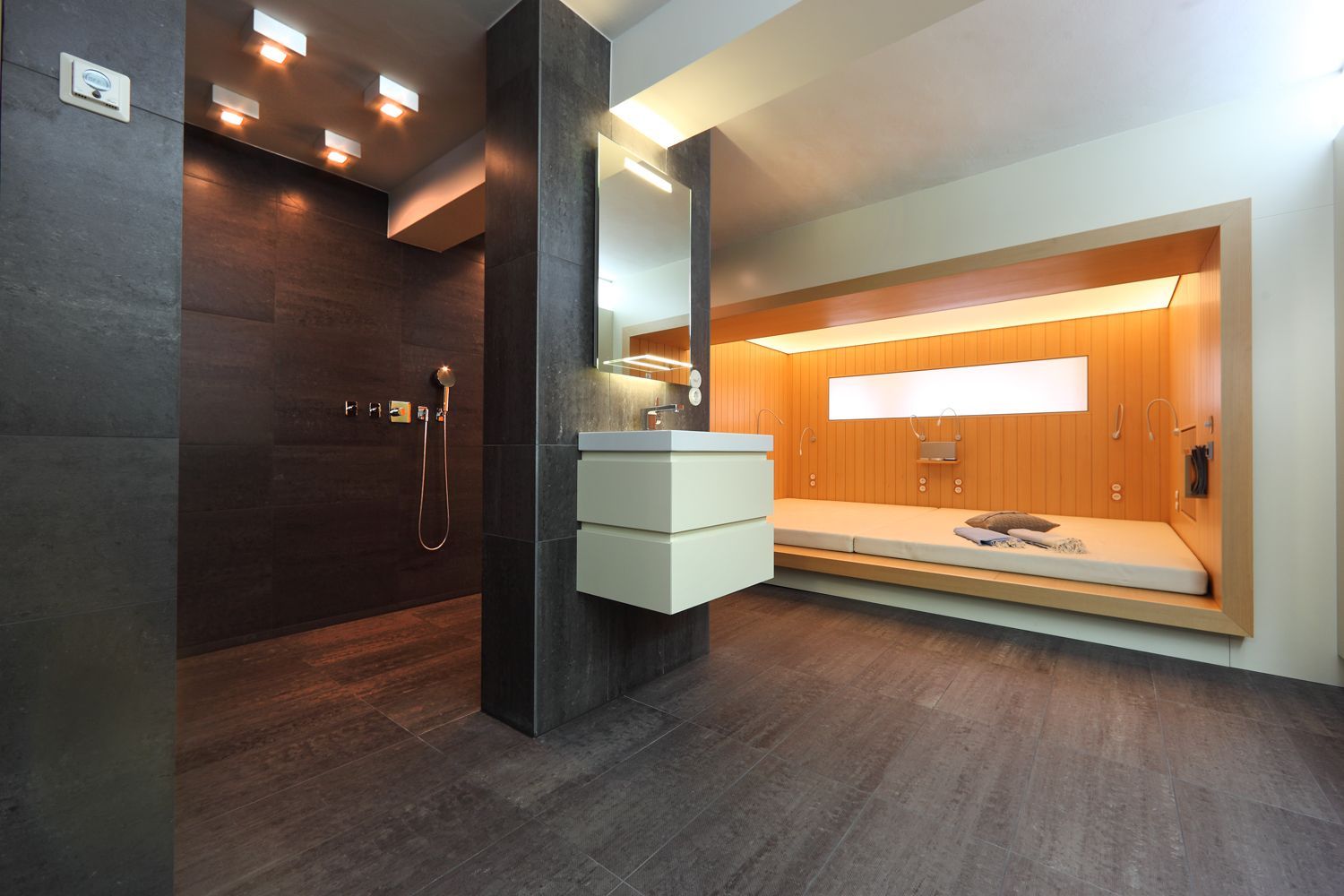 Ein Badezimmer mit Waschbecken und einem Bett in der Ecke