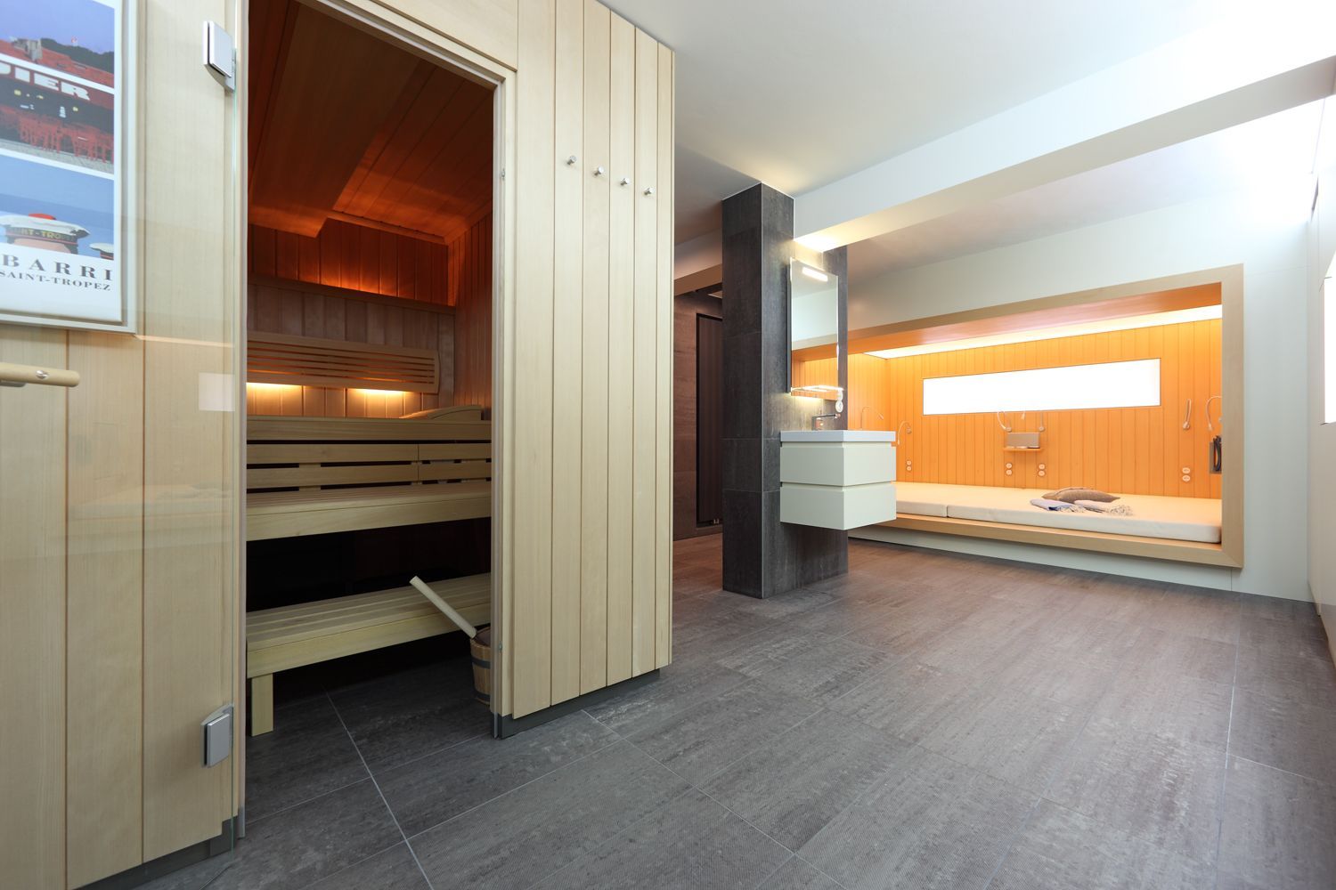 Ein Raum mit einer Holzsauna und einem Bild an der Wand.