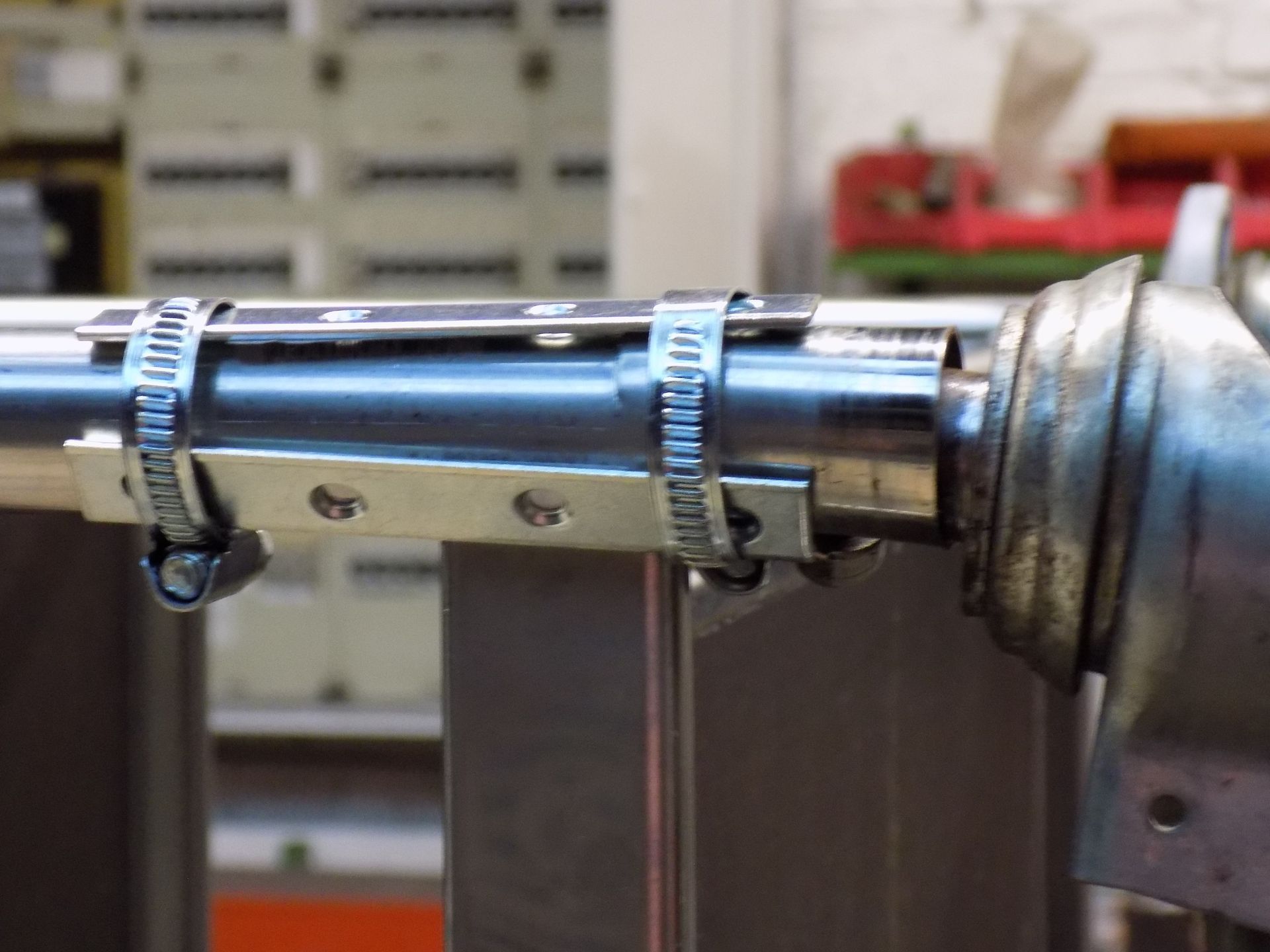 Eine Nahaufnahme eines Metallrohrs mit daran befestigten Schlauchschellen