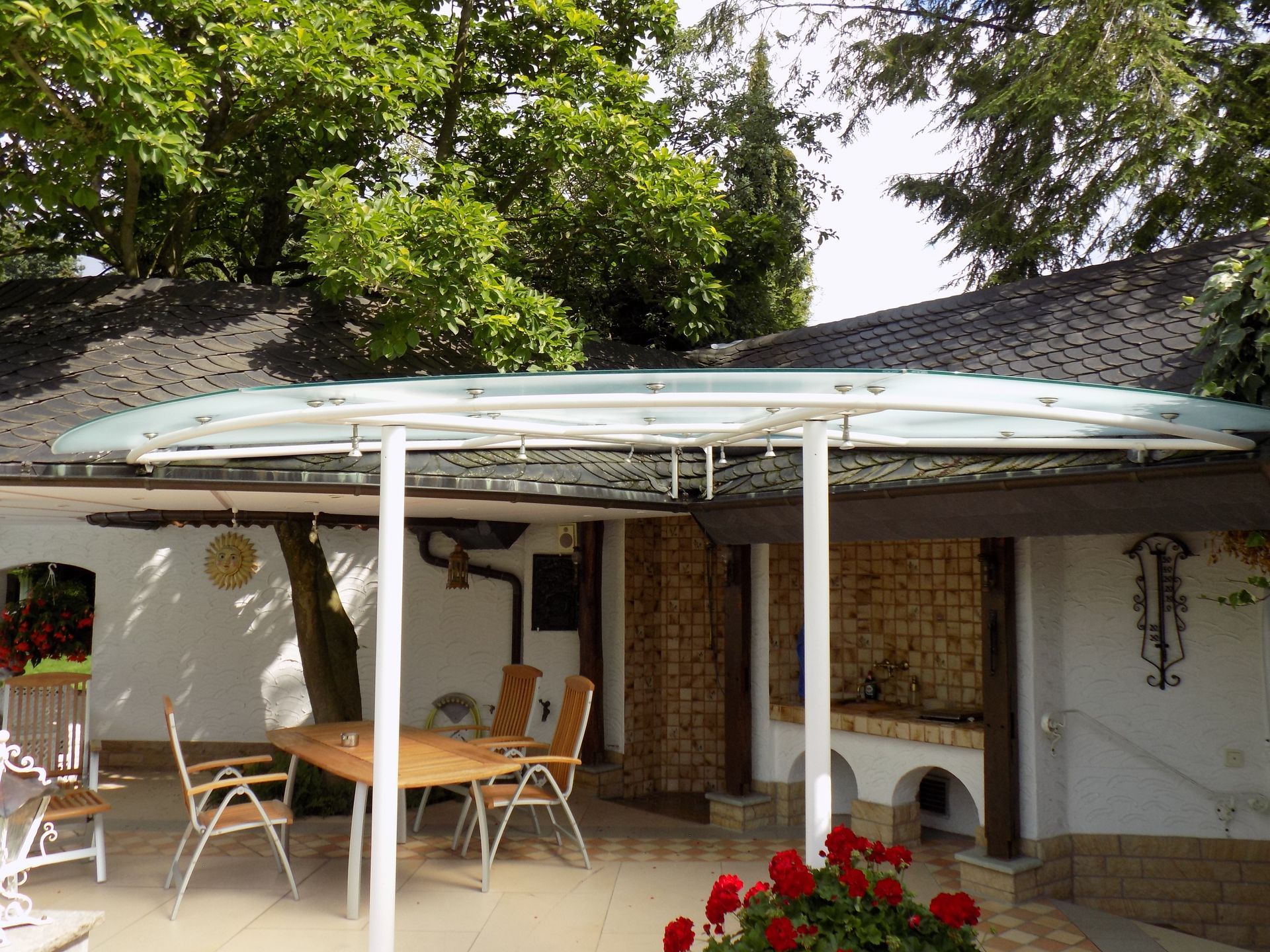 Eine Terrasse mit Tisch und Stühlen unter einem Baldachin