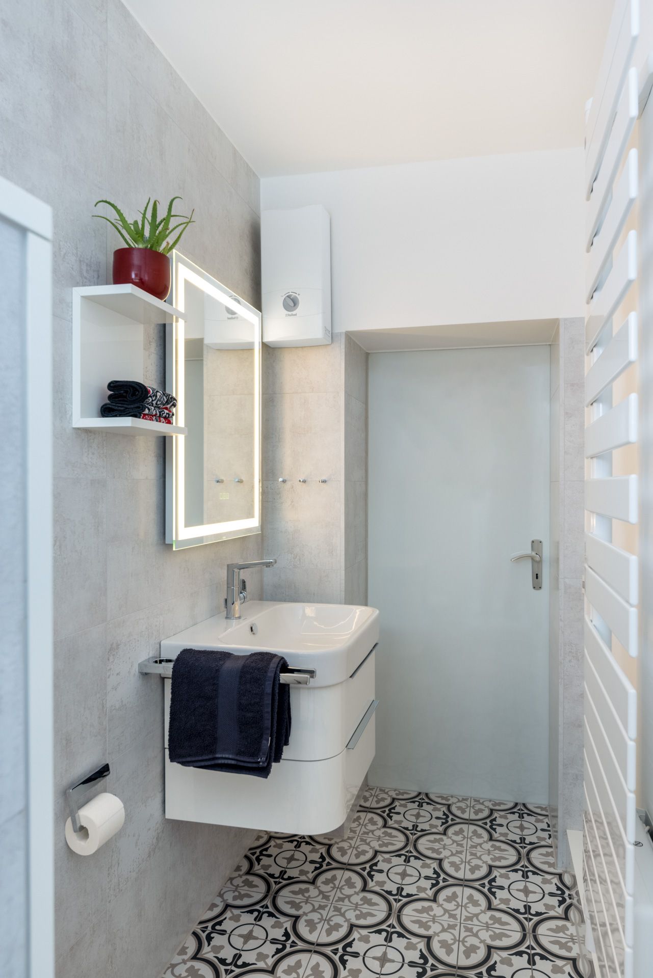 Ein Badezimmer mit Waschbecken, Spiegel und Handtuchhalter.