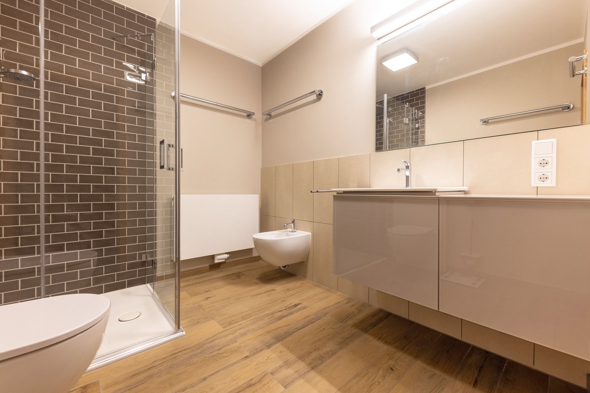 Ein Badezimmer mit Toilette, Waschbecken, Dusche und Spiegel.