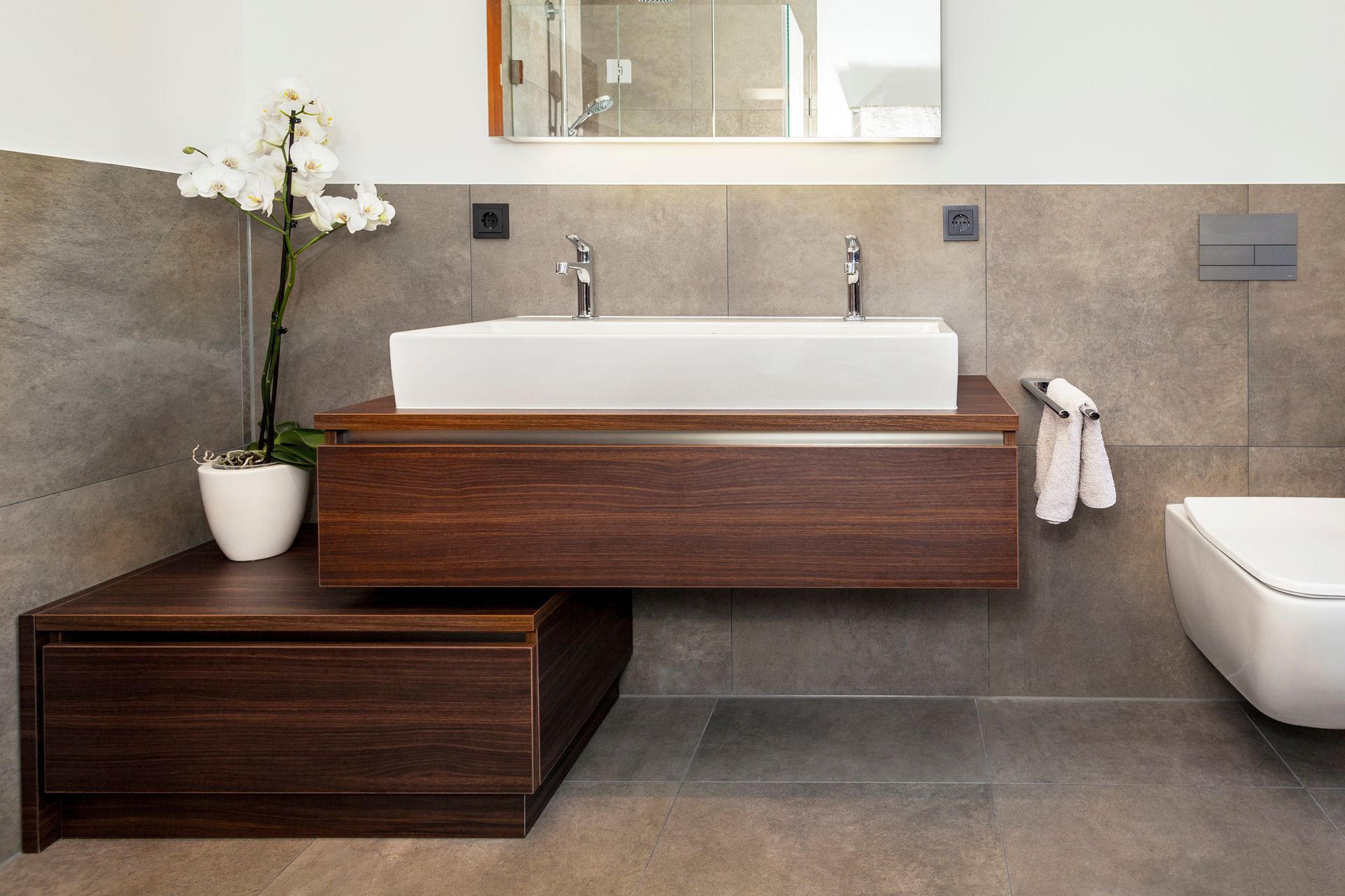 Ein Badezimmer mit zwei Waschbecken, einer Toilette und einem Spiegel.