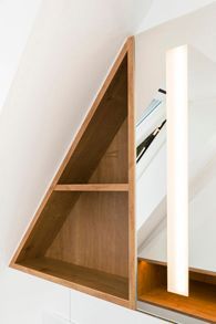 Ein Badezimmer mit einem dreieckigen Regal und einem Spiegel.