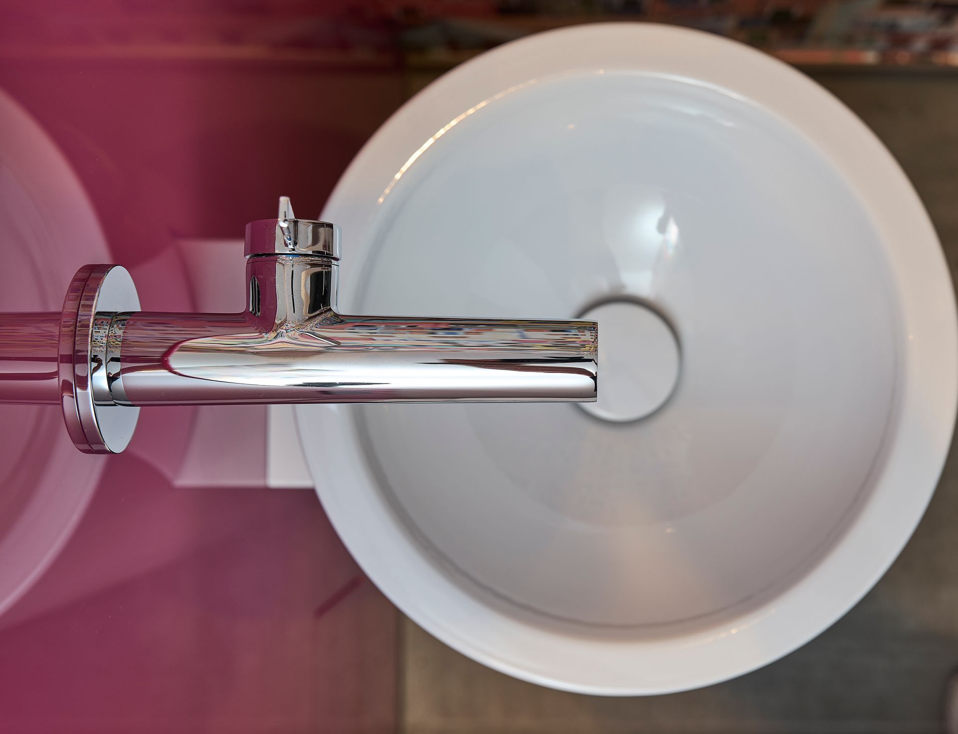 Ein weißes Waschbecken mit einem daran befestigten Chromhahn