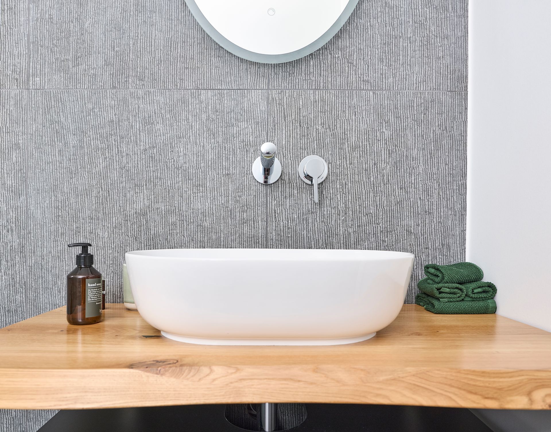 Ein Badezimmer mit Waschbecken und Spiegel an der Wand