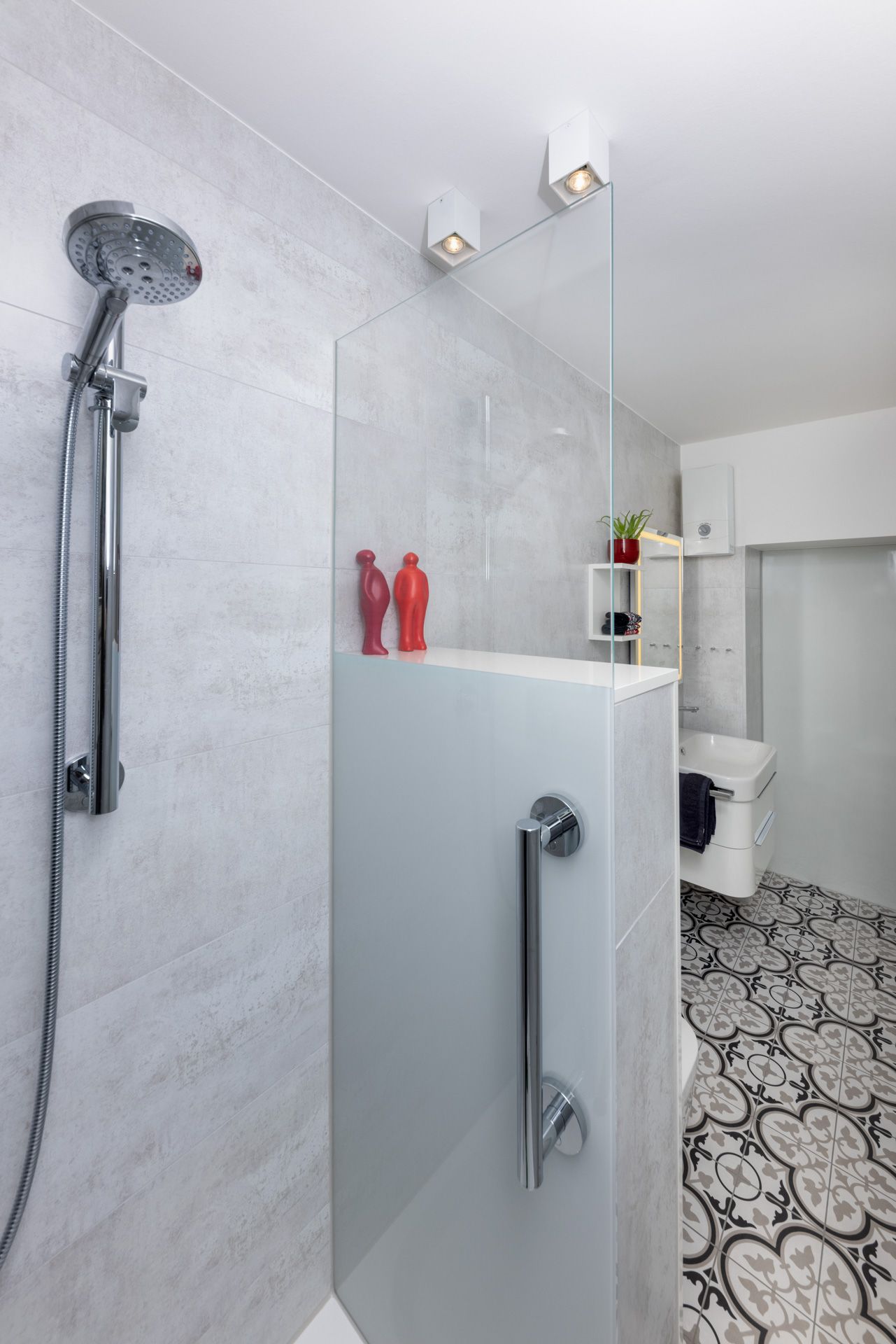 Ein Badezimmer mit ebenerdiger Dusche und Waschbecken.