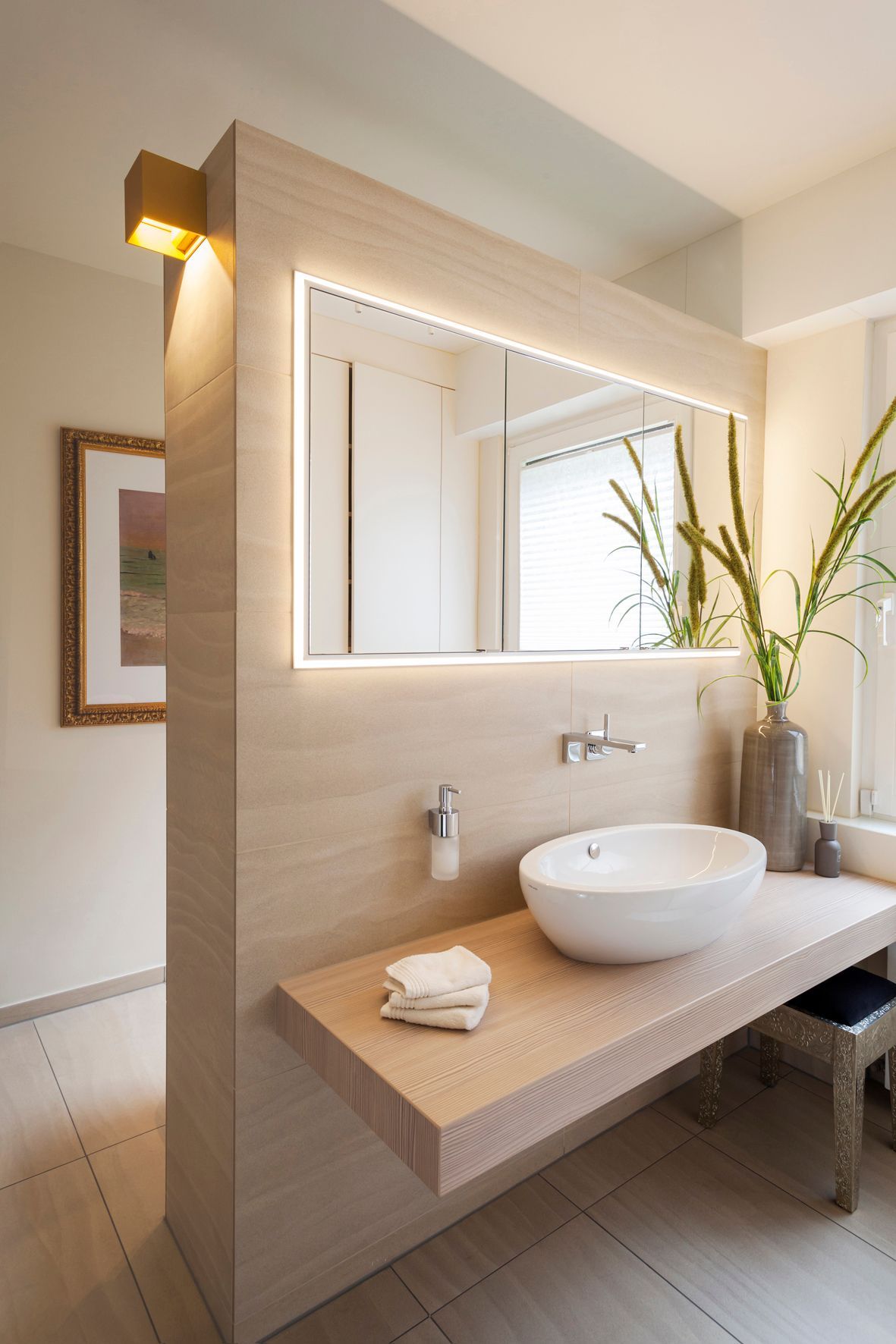 Ein Badezimmer mit Waschbecken, Spiegel und Holzablage.