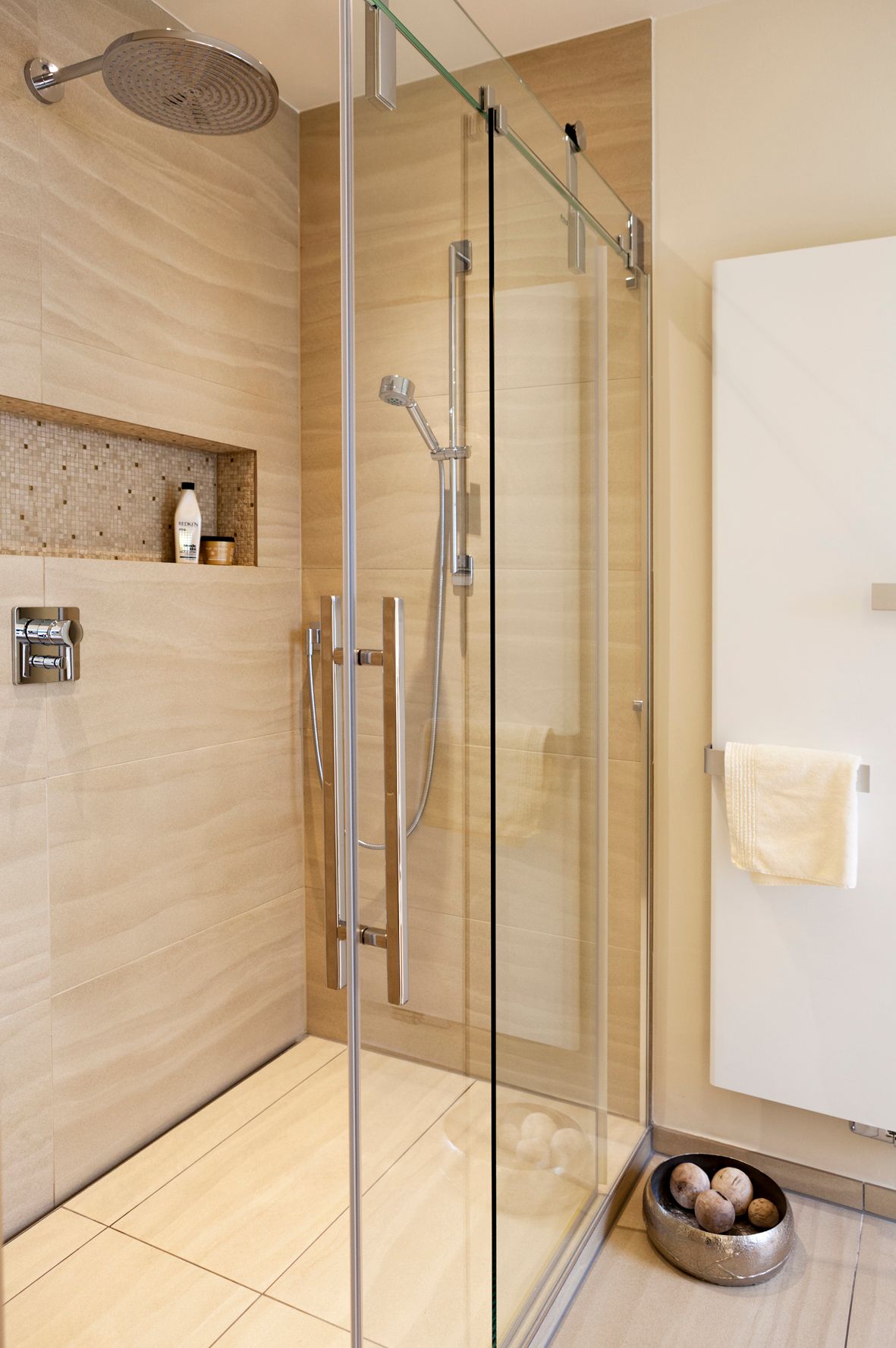 Ein Badezimmer mit ebenerdiger Dusche mit Glastür.