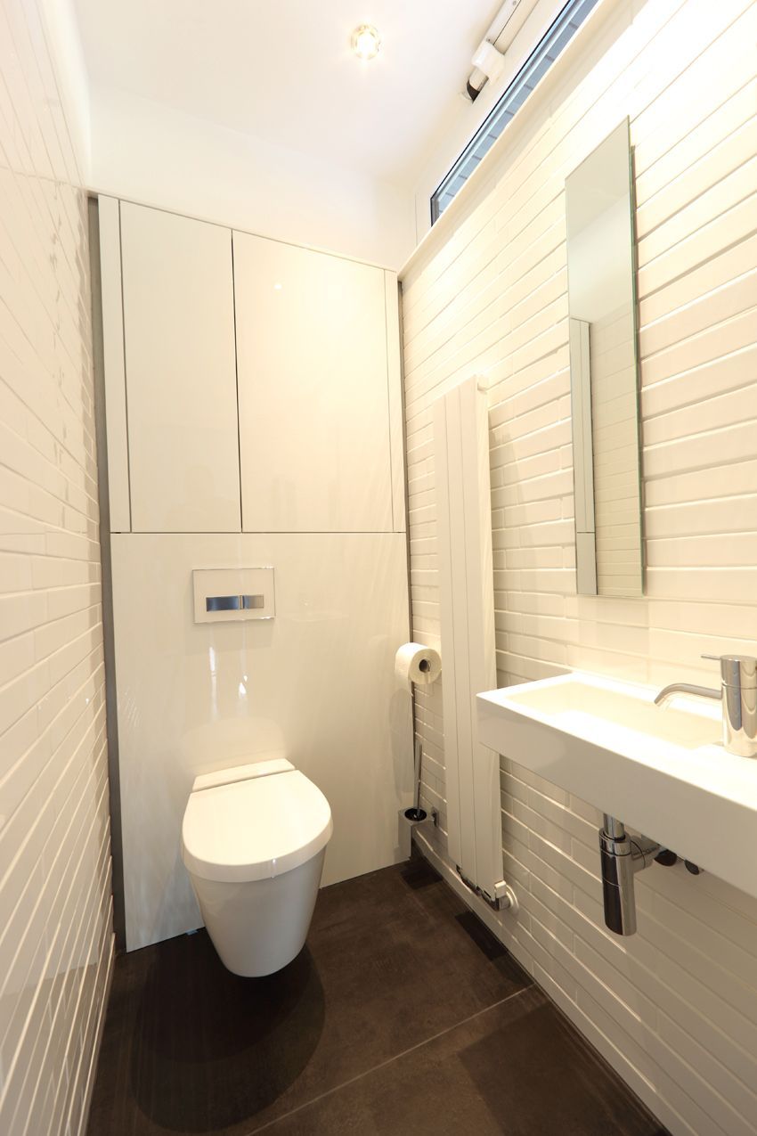 Ein Badezimmer mit Toilette, Waschbecken und Spiegel