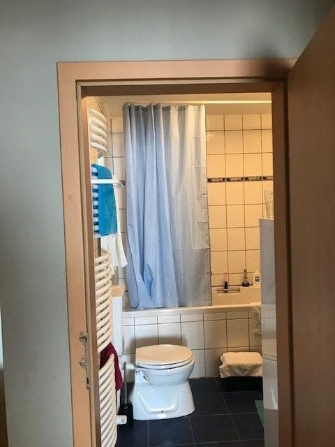 Ein Badezimmer mit Toilette, Badewanne und Handtuchhalter