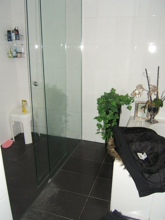 Ein Badezimmer mit ebenerdiger Dusche und Badewanne