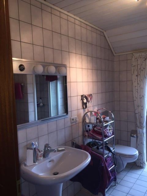 Ein Badezimmer mit Waschbecken, Toilette und Spiegel