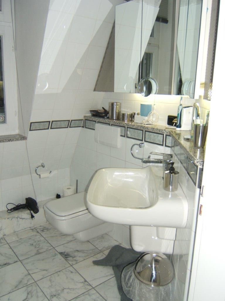 Ein Badezimmer mit Waschbecken, Toilette und Spiegel